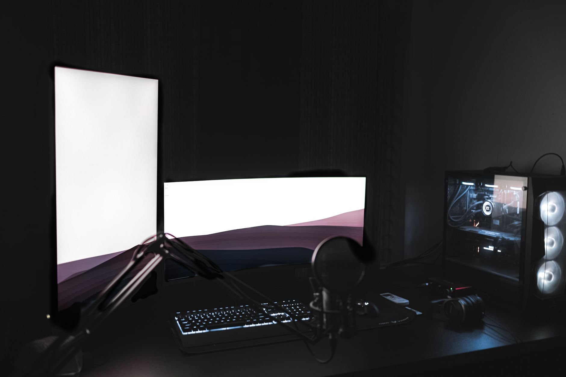 Gaming setup with glowing monitors in dark studio